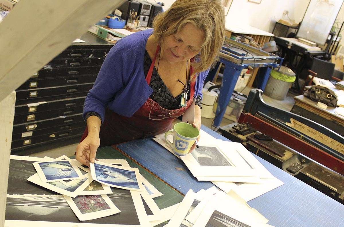 Morna Rhys looking over her prints